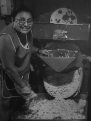 Fotografía de una mujer produciendo masa de maíz en la tortillería de un mercado de Tabasco